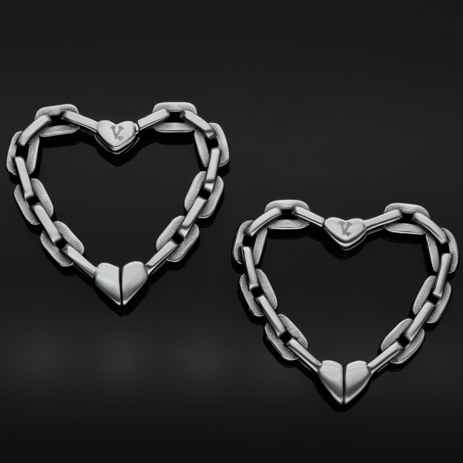 Pendientes de corazón de plata hechos de eslabones sobre fondo negro