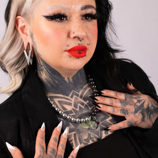 Mujer con tatuajes lleva Collar de Burbujas de Gato en Plata y Negro y piercings, fondo negro