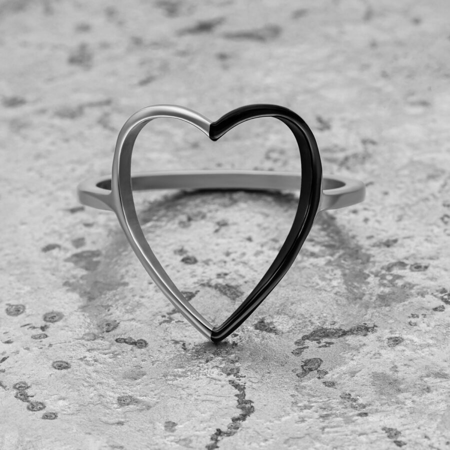 Anillo de corazón bicolor en plata y negro sobre fondo gris