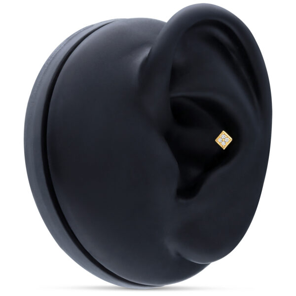 Accesorio de piercing cuadrado de oro en display negro para oreja