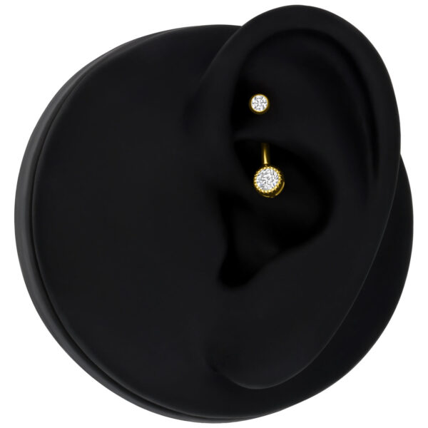 Piercing dorado con cristal claro en modelo de oreja negra