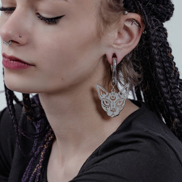 Mujer con trenzas lleva una pesa para orejas Sphynx en plata.
