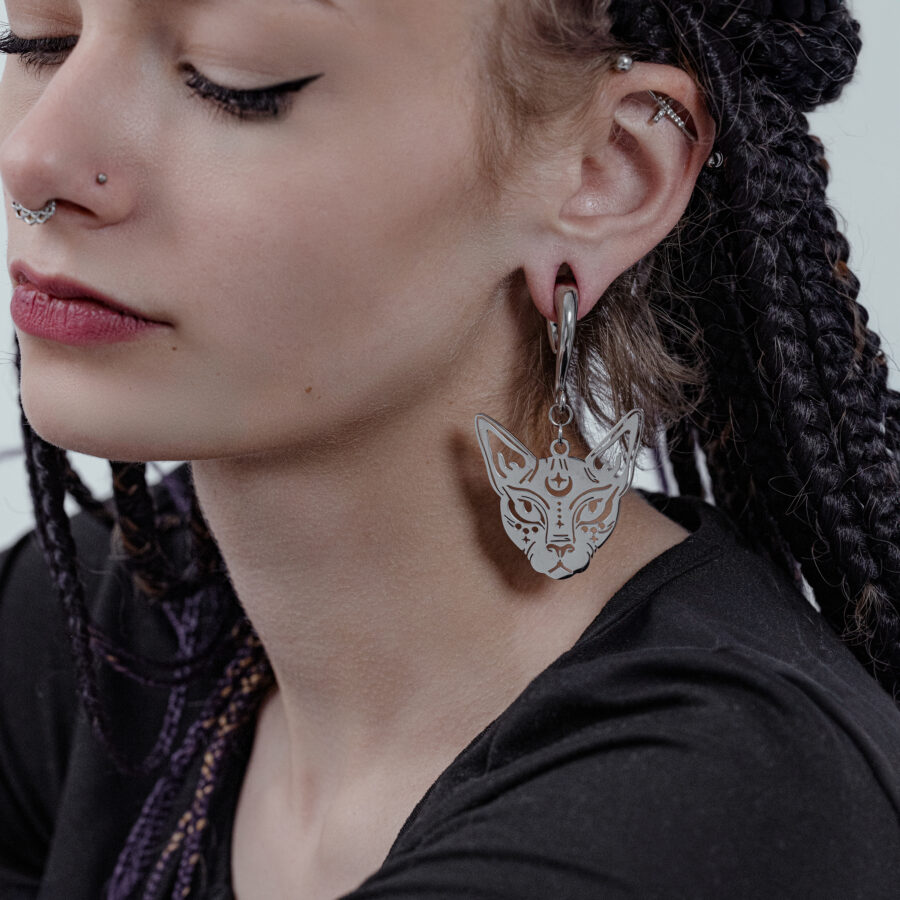 Mujer con trenzas lleva una pesa para orejas Sphynx en plata.