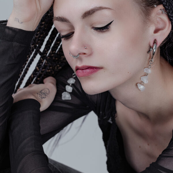 Mujer con pesas para orejas Rocks de plata y piercing en la nariz