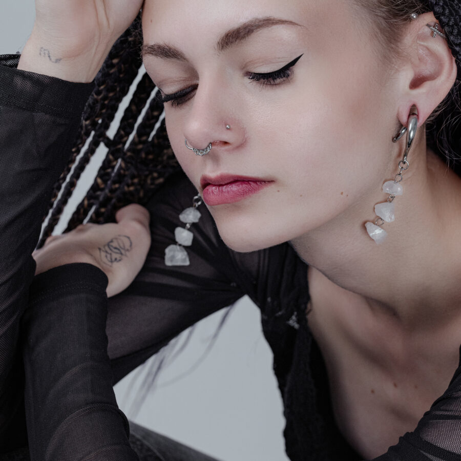 Mujer con pesas para orejas Rocks de plata y piercing en la nariz