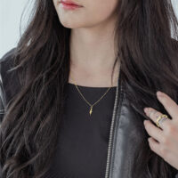 Mujer con cadena Little Snake dorada, atuendo negro, cabello largo