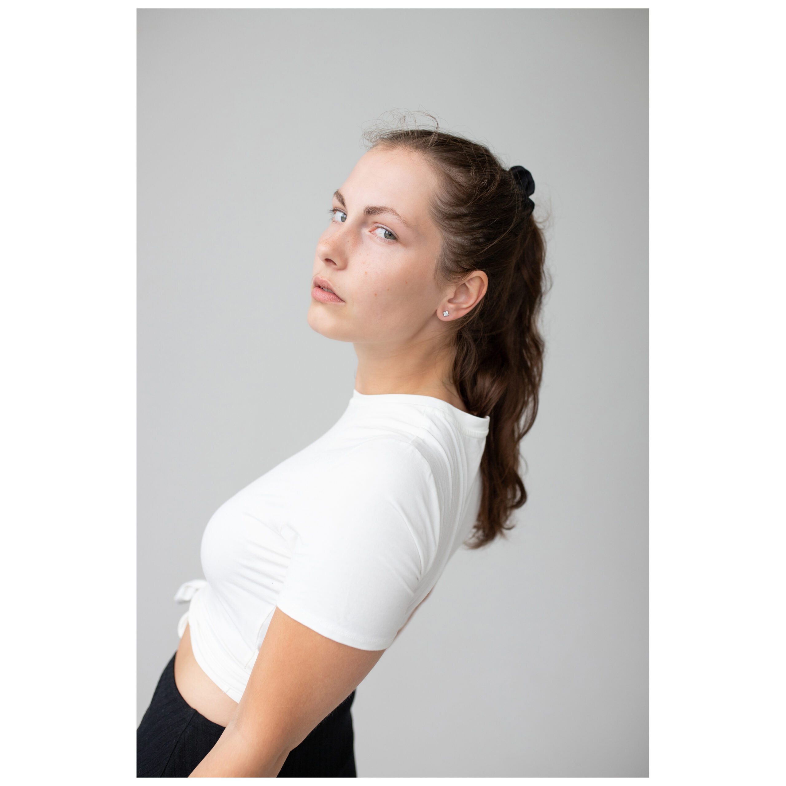 Roségoldene Crystal Square Ohrstecker Model trägt roségoldene Crystal Square Ohrstecker vor grauem Hintergrund