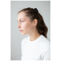 Frau mit Roségold Ohrstecker auf hellgrauem Hintergrund