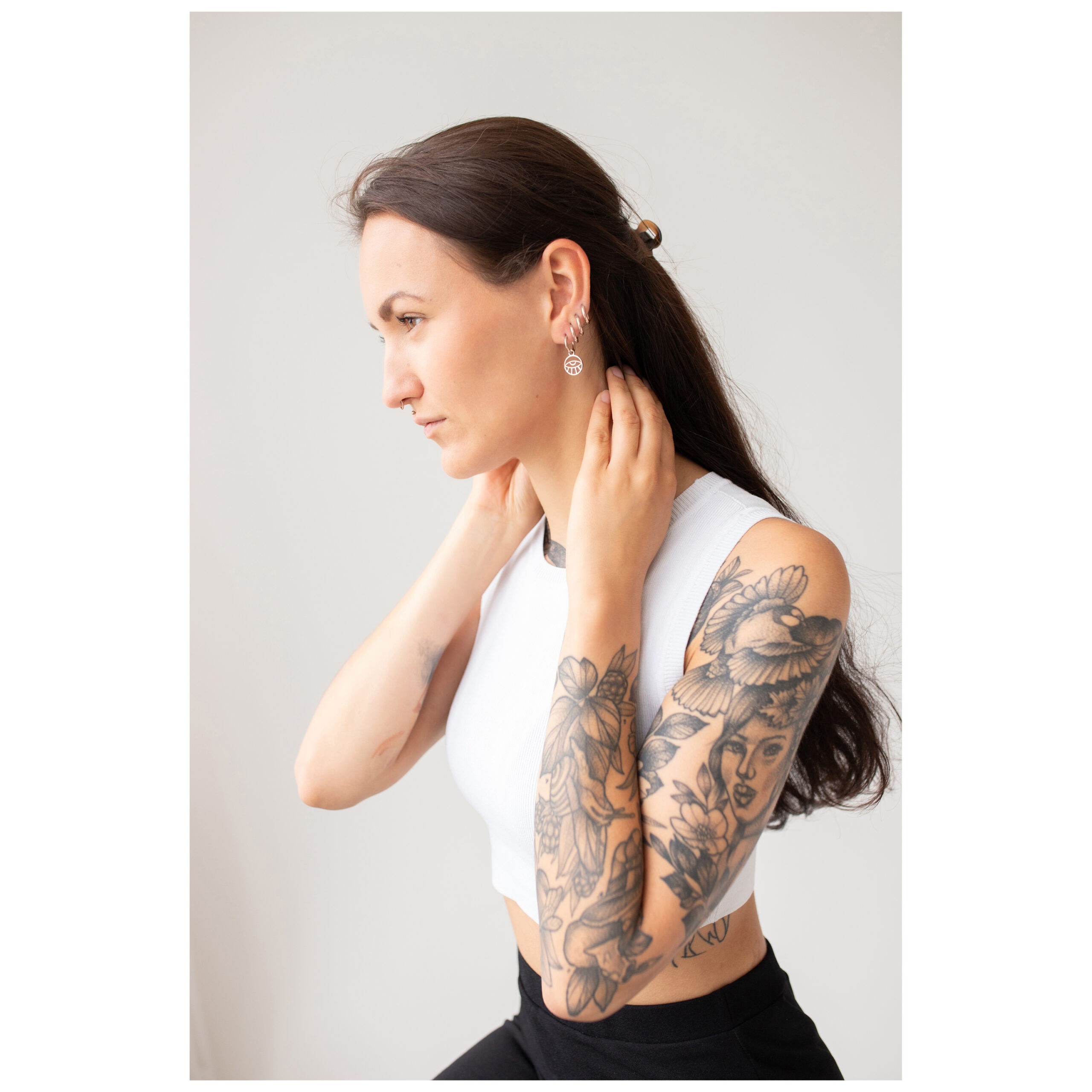 Roségoldene Petits Anneaux - Oeil Ohrhänger Frau mit roségoldenen Ohrringen in Auge-Design vor weißem Hintergrund