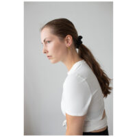 Mujer con blusa blanca lleva aros dorados Little Long Spike frente a un fondo neutro