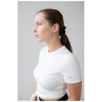 Mujer con aros dorados Little 5 Rings, camisa blanca, fondo claro