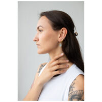 Mujer con aros Little Mystic Snake dorados sobre fondo gris