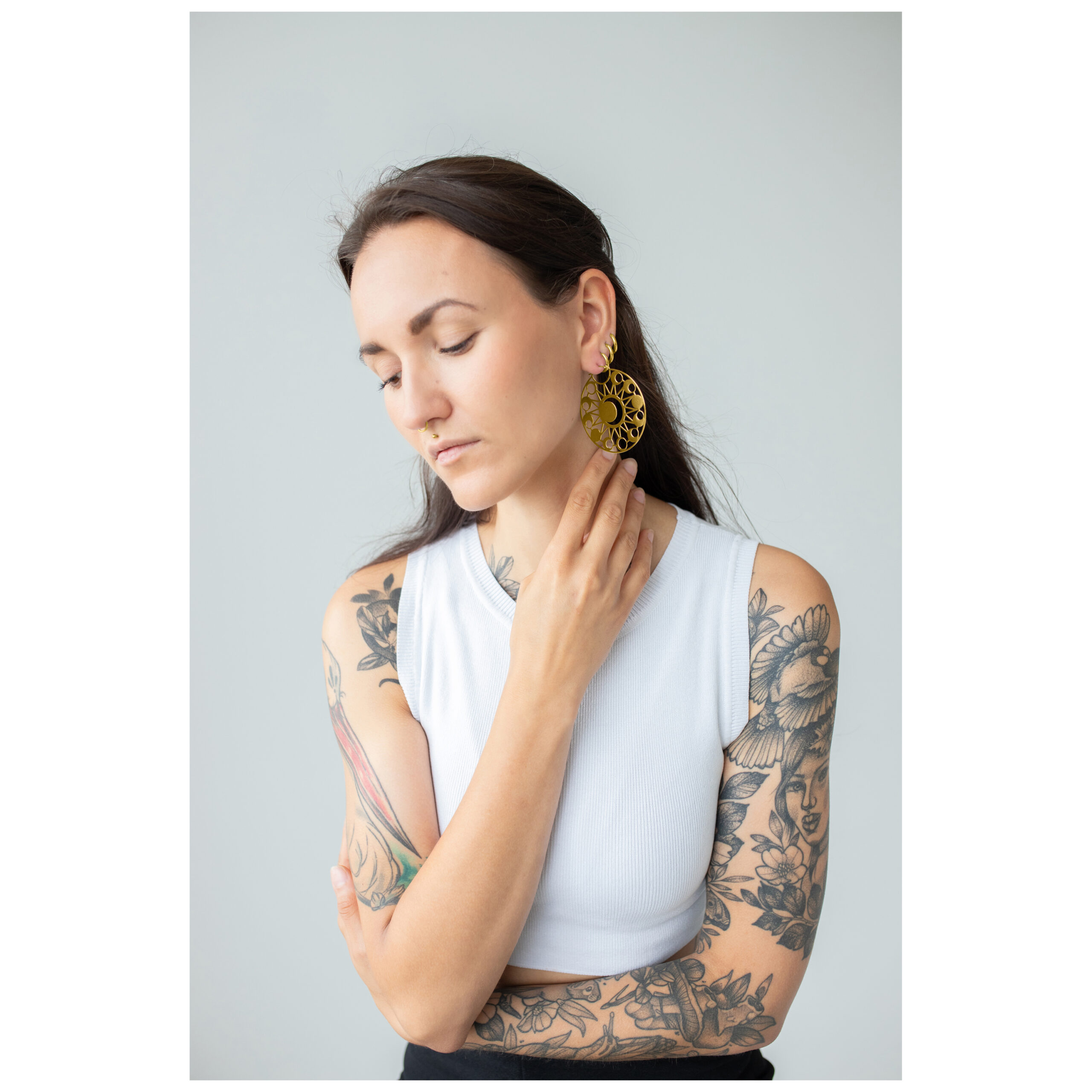 Aros Dorados Moon Eclipse Mujer con cabello largo y negro lleva aros dorados Moon Eclipse frente a un fondo gris