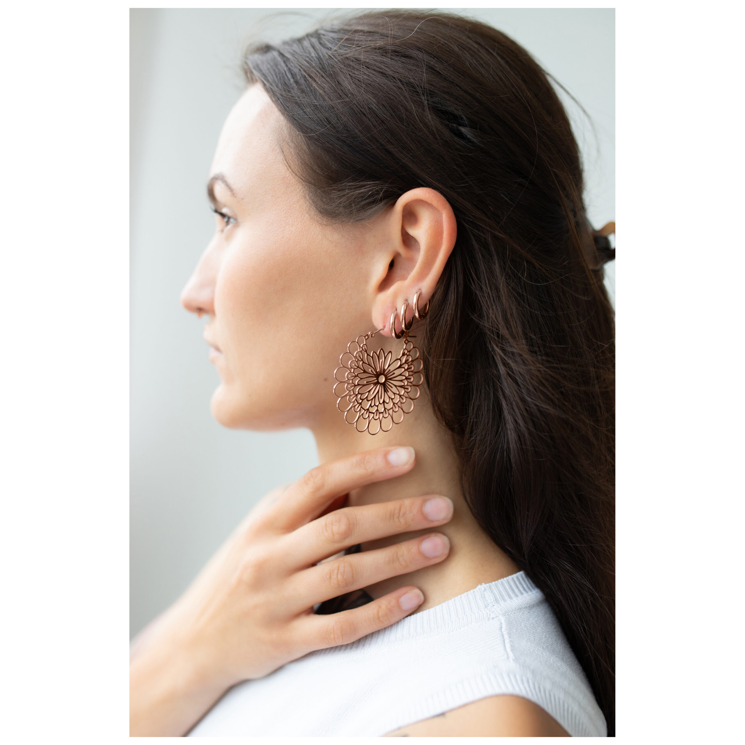 Frau mit Roségold Daisy Hoops Ohrringen im Ohr, seitliches Profil