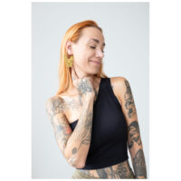 Aros Bulldog de Oro en la Oreja Mujer con aros Bulldog de oro, sonriendo con tatuajes