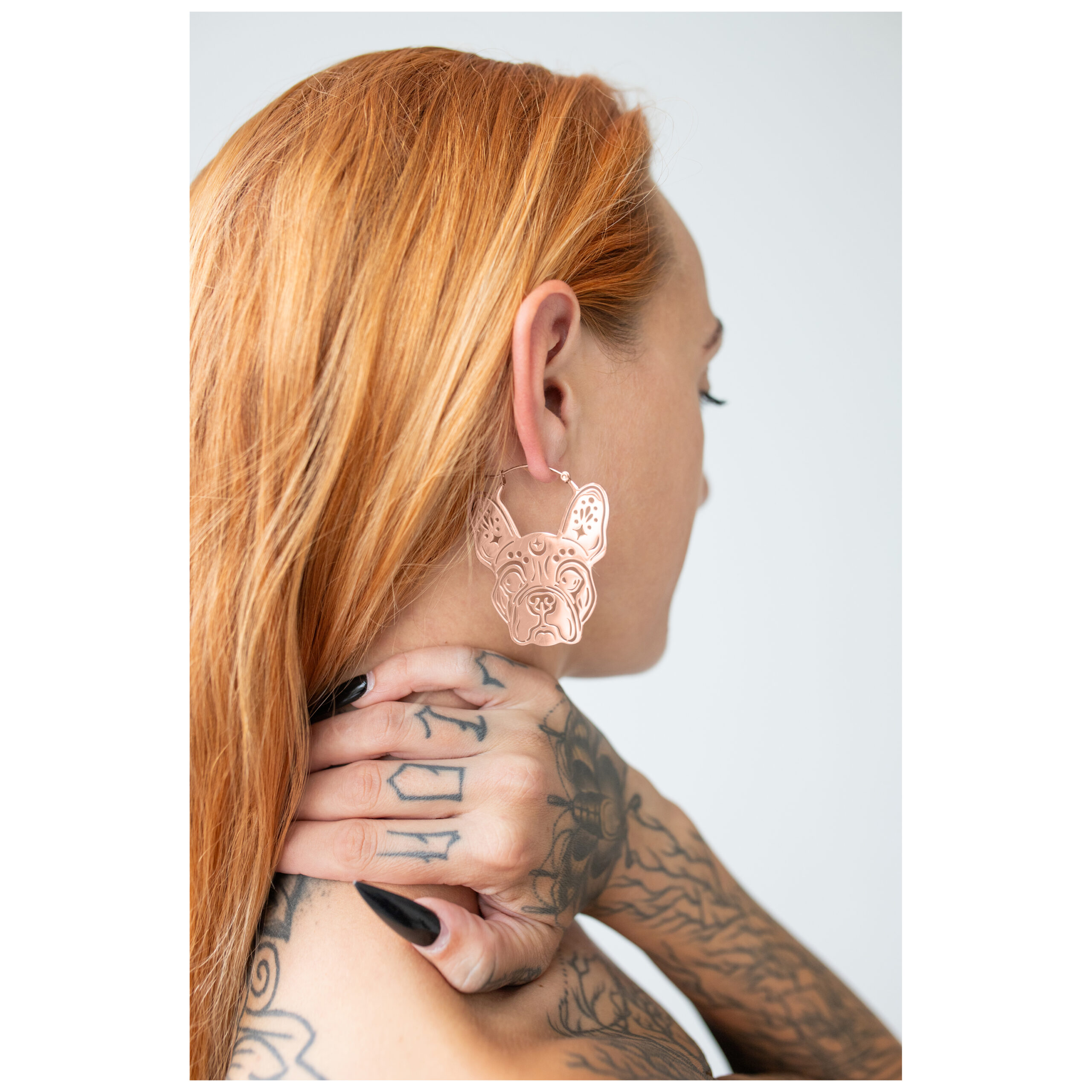 Bulldog Hoops in Roségold Roségoldene Bulldog Ohrringe am Ohr einer Person mit roten Haaren und Tattoos