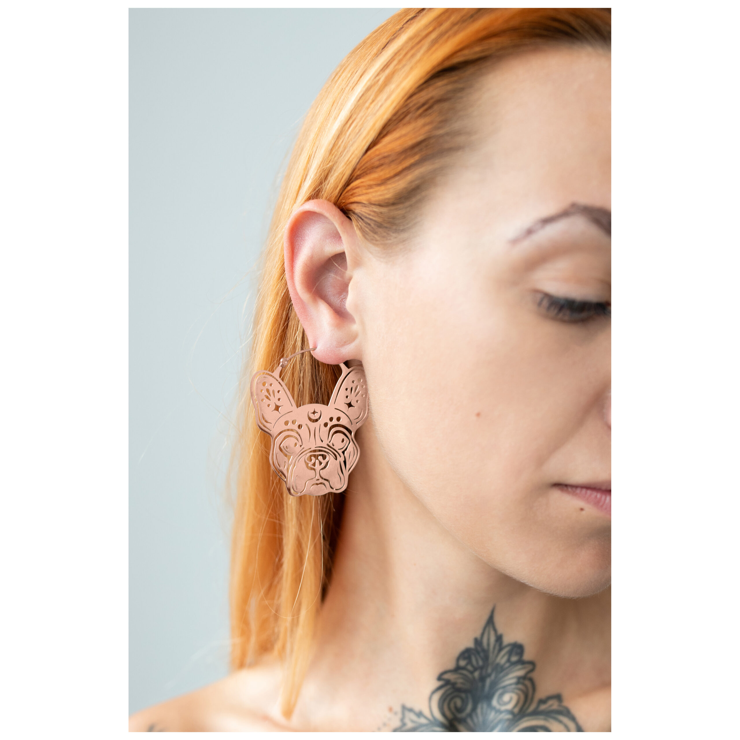 Bulldog Ohrringe in Roségold Frau mit roségoldenen Bulldog Ohrringen auf hellem Hintergrund