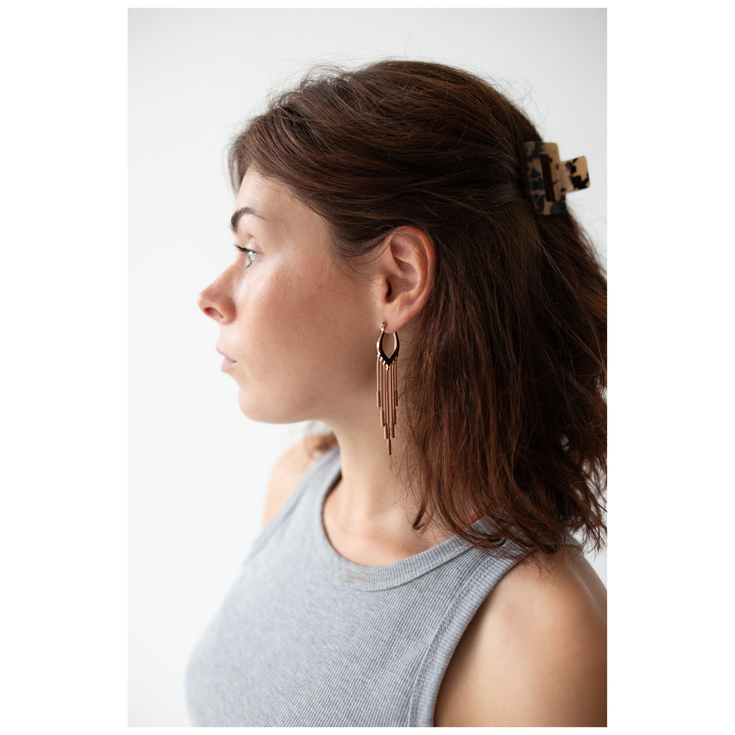 Frau mit roségoldenen Snakechain Hoops Ohrringen seitlich auf weißem Hintergrund