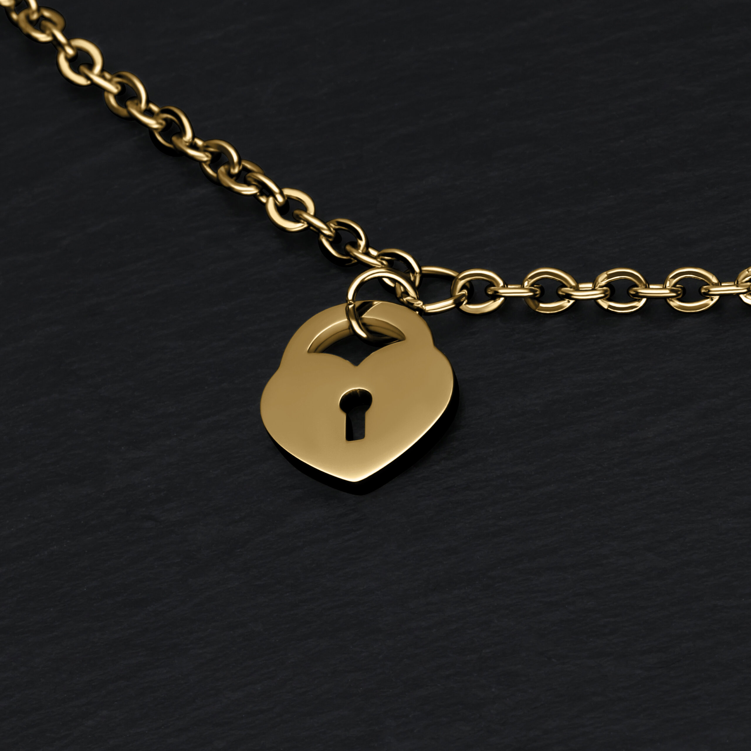Pulsera dorada con candado en forma de corazón sobre fondo negro
