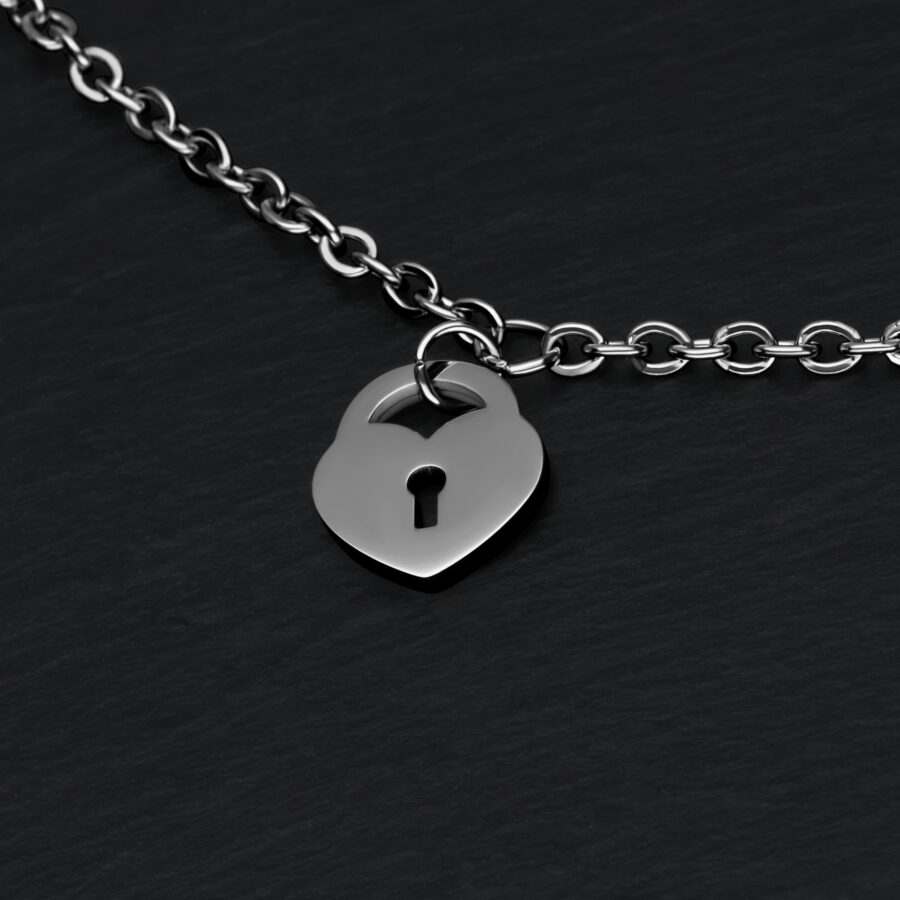 Pulsera de plata con colgante de candado en forma de corazón sobre fondo negro