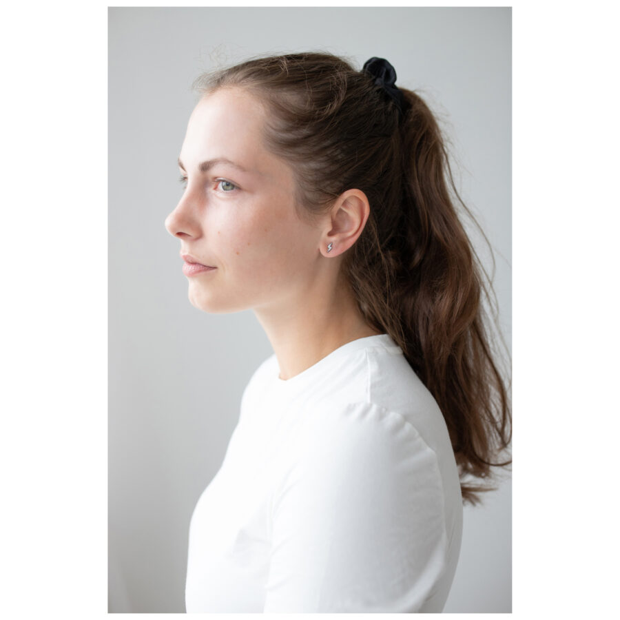 Mujer con cabello largo lleva pendientes de plata Crystal Lightning.