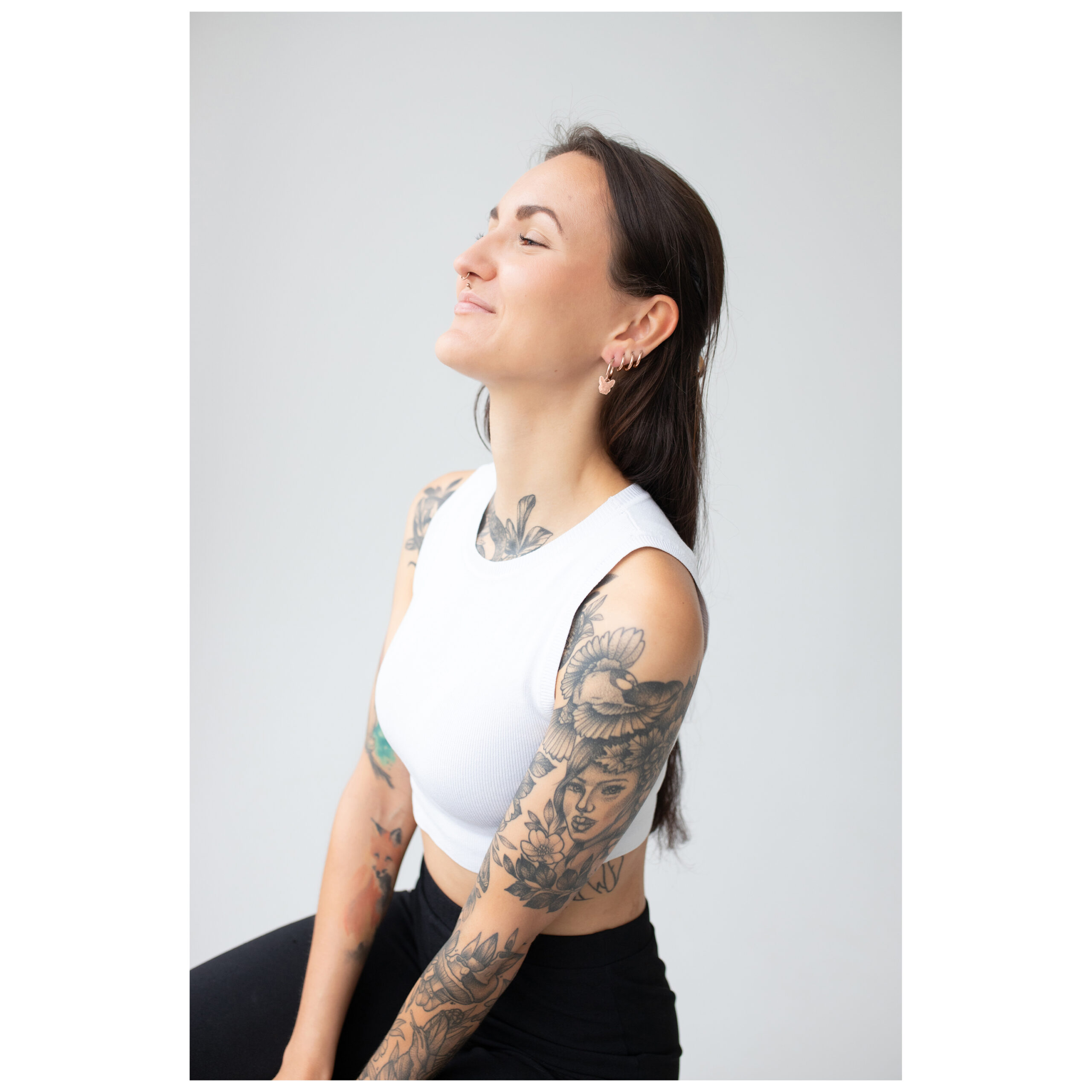 Frau mit weißen Top trägt roségoldene Little Bulldog Hoops auf hellem Hintergrund