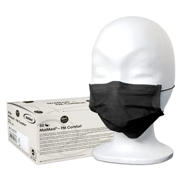 Mascarilla desechable negra MaiMed en cabeza de modelo blanco con embalaje al fondo