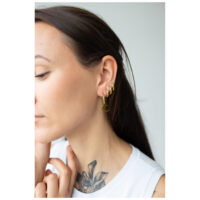 Aros dorados Little Moonchild en la oreja Mujer lleva aros dorados Little Moonchild, retrato lateral