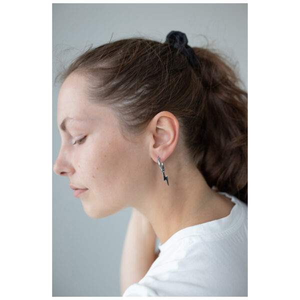 Mujer con coleta negra lleva Little Flash Hoops pendientes de acero quirúrgico