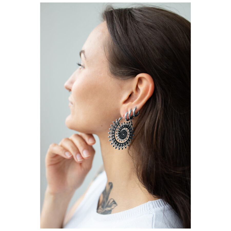 Mujer con aros Floral Nautilus en plata y oro sobre fondo neutro