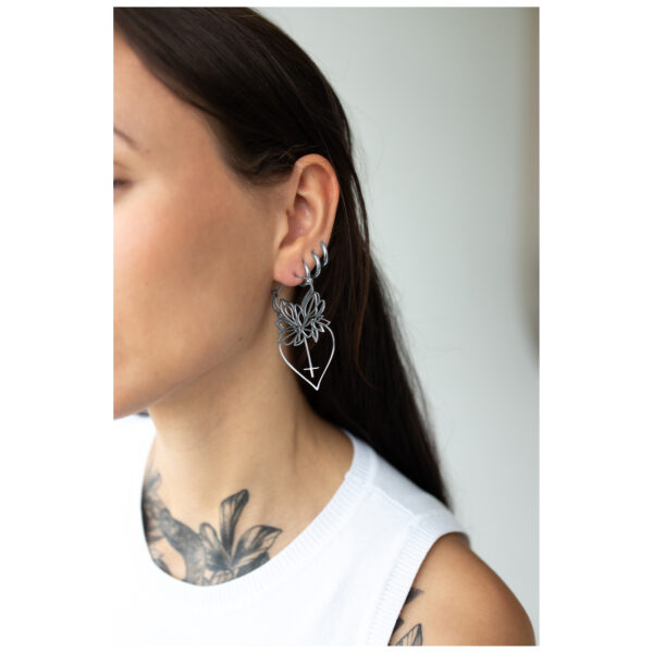 Mujer con pendientes Dahlia Hoops en negro y plata, retrato lateral