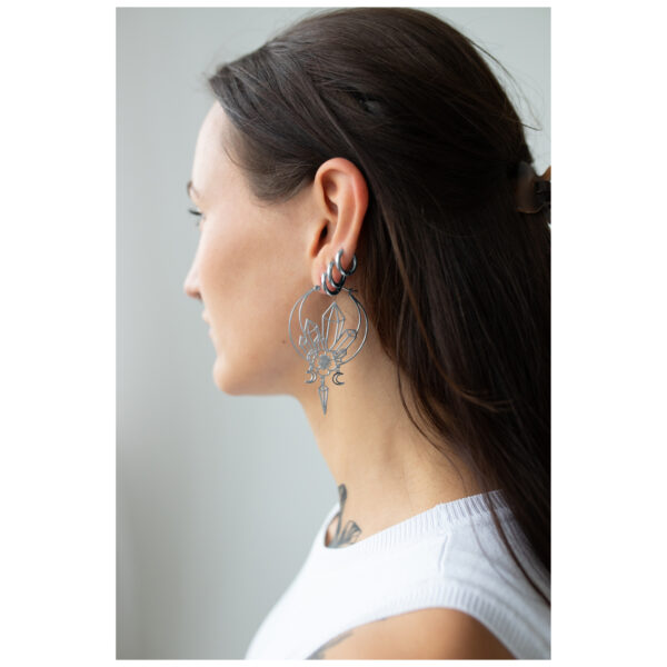 Joven con cabello largo lleva grandes aros Oracle negros de perfil