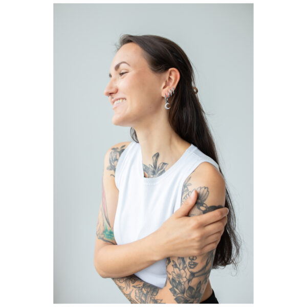 Mujer con brazos tatuados lleva aros Little Moonchild plateados
