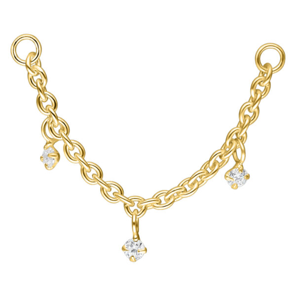 Cadena de piercing dorada con colgantes de cristal sobre fondo blanco