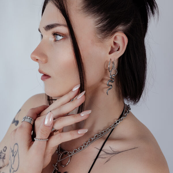 Mujer con aros Big Snake de plata, perfil lateral