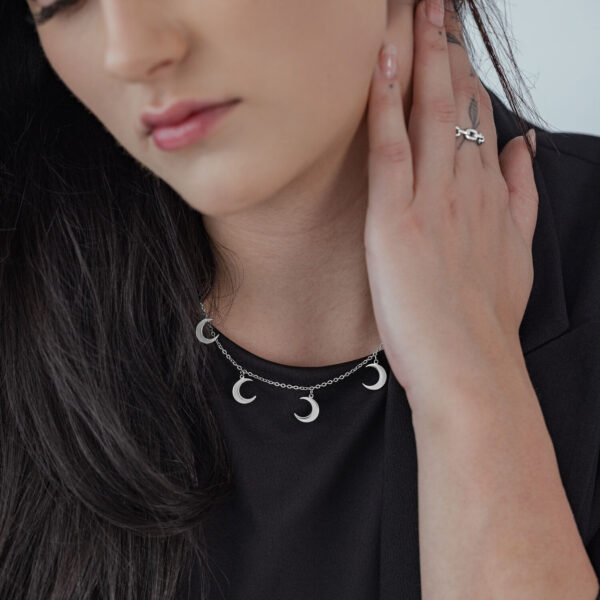Mujer lleva collar de plata Little Moon con varios colgantes de luna sobre prenda negra