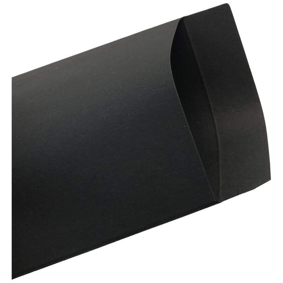 Bolsa de regalo de papel negra sobre fondo blanco, ligeramente abierta