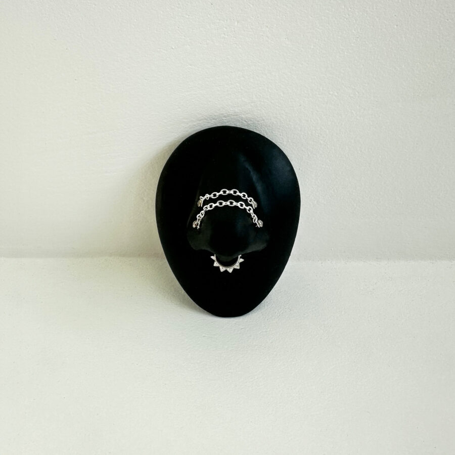 Cadena de piercing plateada de Wildcat sobre exhibidor ovalado negro