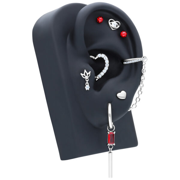 Cadena de piercing plateada y joyería en soporte negro para oreja, piedras rojas