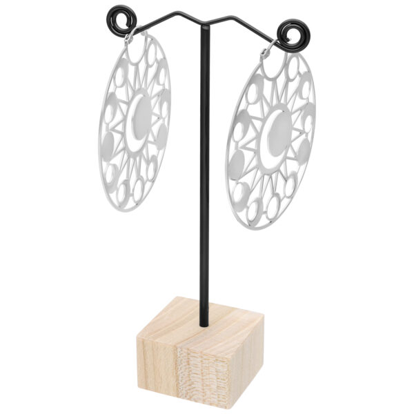 Soporte negro para pendientes con dos grandes pendientes plateados, base de madera