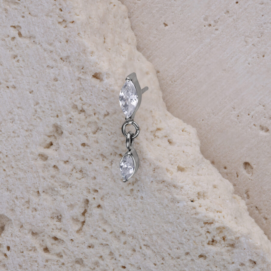 Adorno de piercing de cristal ovalado en plata sobre piedra clara