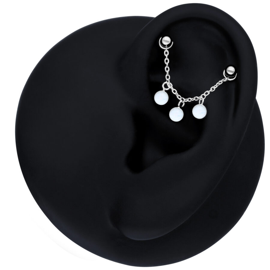 Cadena de piercing negra con ópalo sintético en la oreja sobre fondo negro