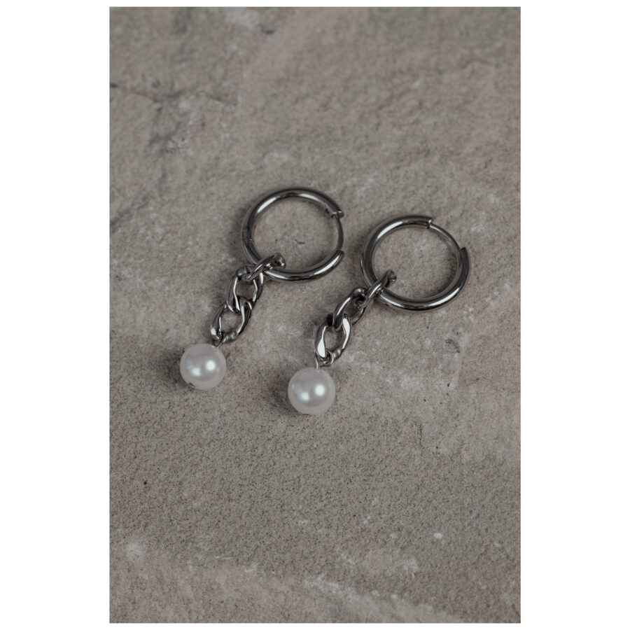Dos aros de plata con pequeños colgantes de perla sobre piedra gris