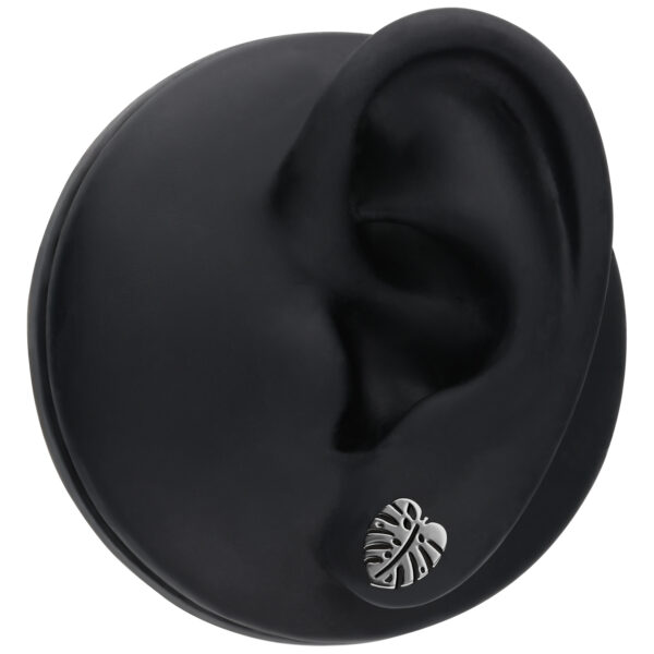 Pendientes de Monstera plateados en oreja de modelo negra en foto de estudio