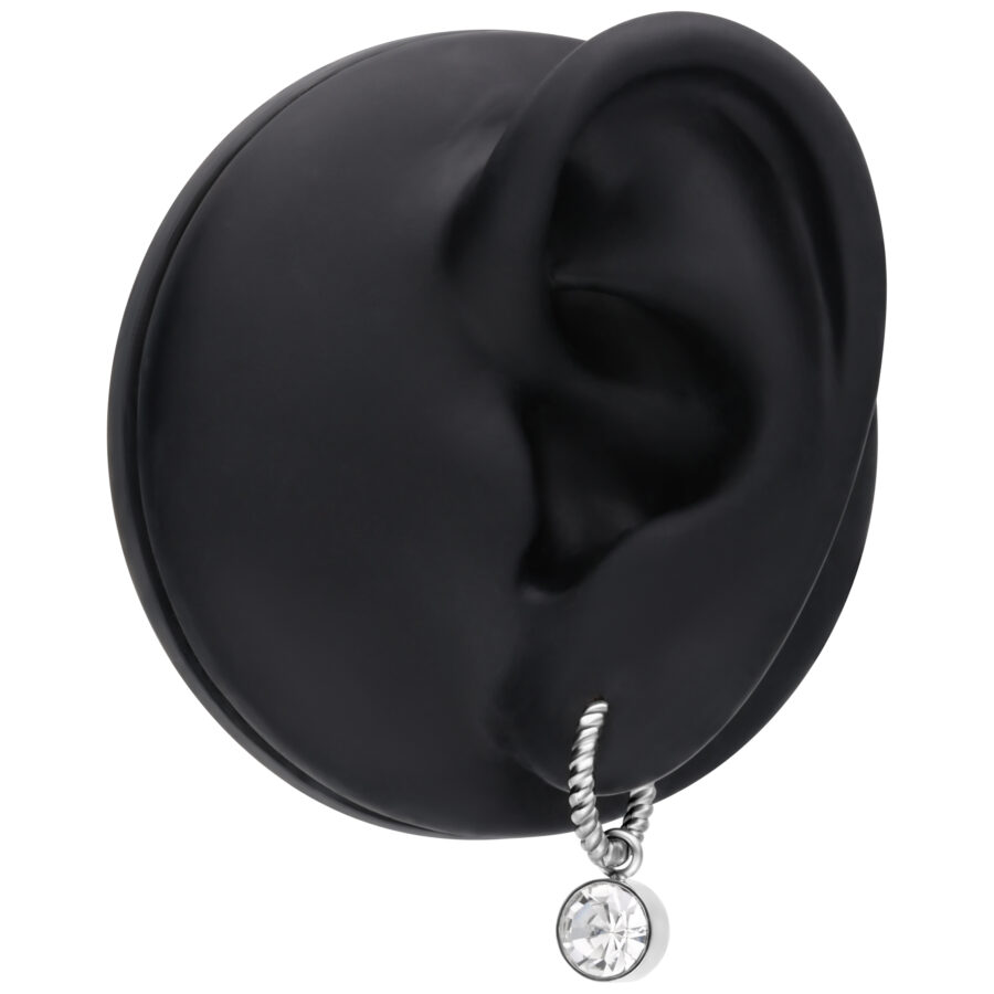 Pendientes plateados con diseño torcido y colgante de cristal en un expositor de oreja negro