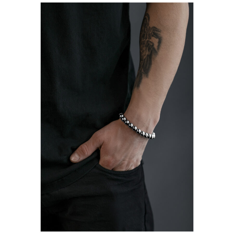 Pulsera Bubble plateada en una muñeca tatuada sobre fondo gris