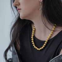 Mujer con top negro y collar burbuja dorado de Wildcat