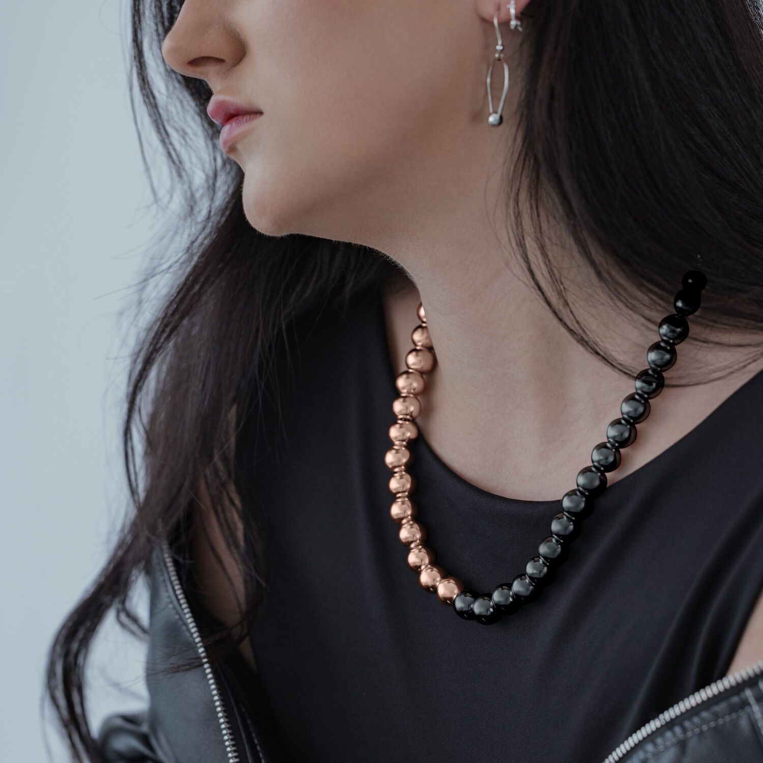 Mujer lleva Collar Bubble en oro rosa y negro sobre fondo gris