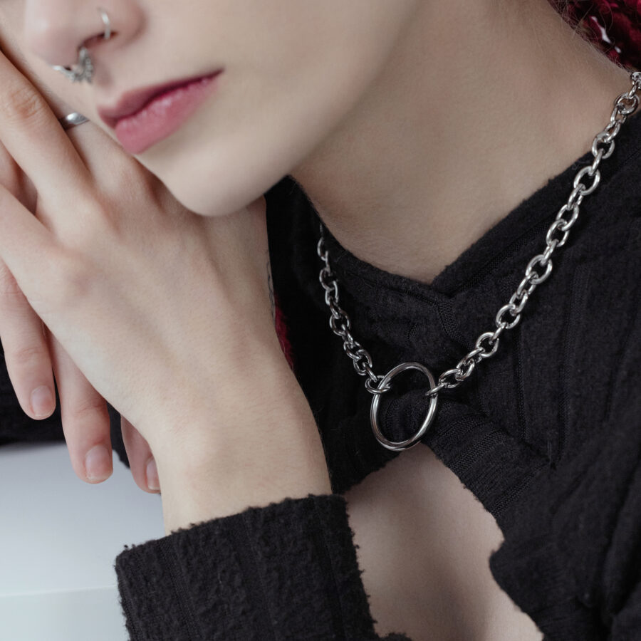 Collar unisex O de acero quirúrgico negro y plateado en persona