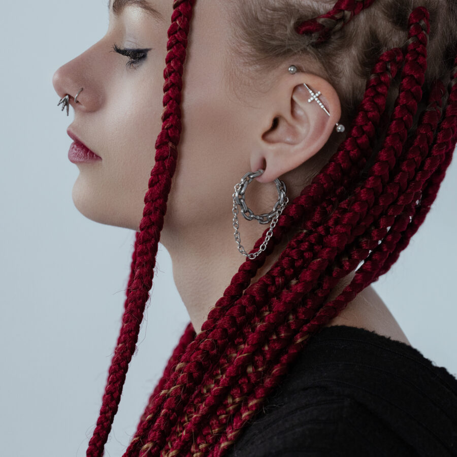 Mujer con trenzas rojas lleva pesos para orejas de doble cadena de acero quirúrgico plateado